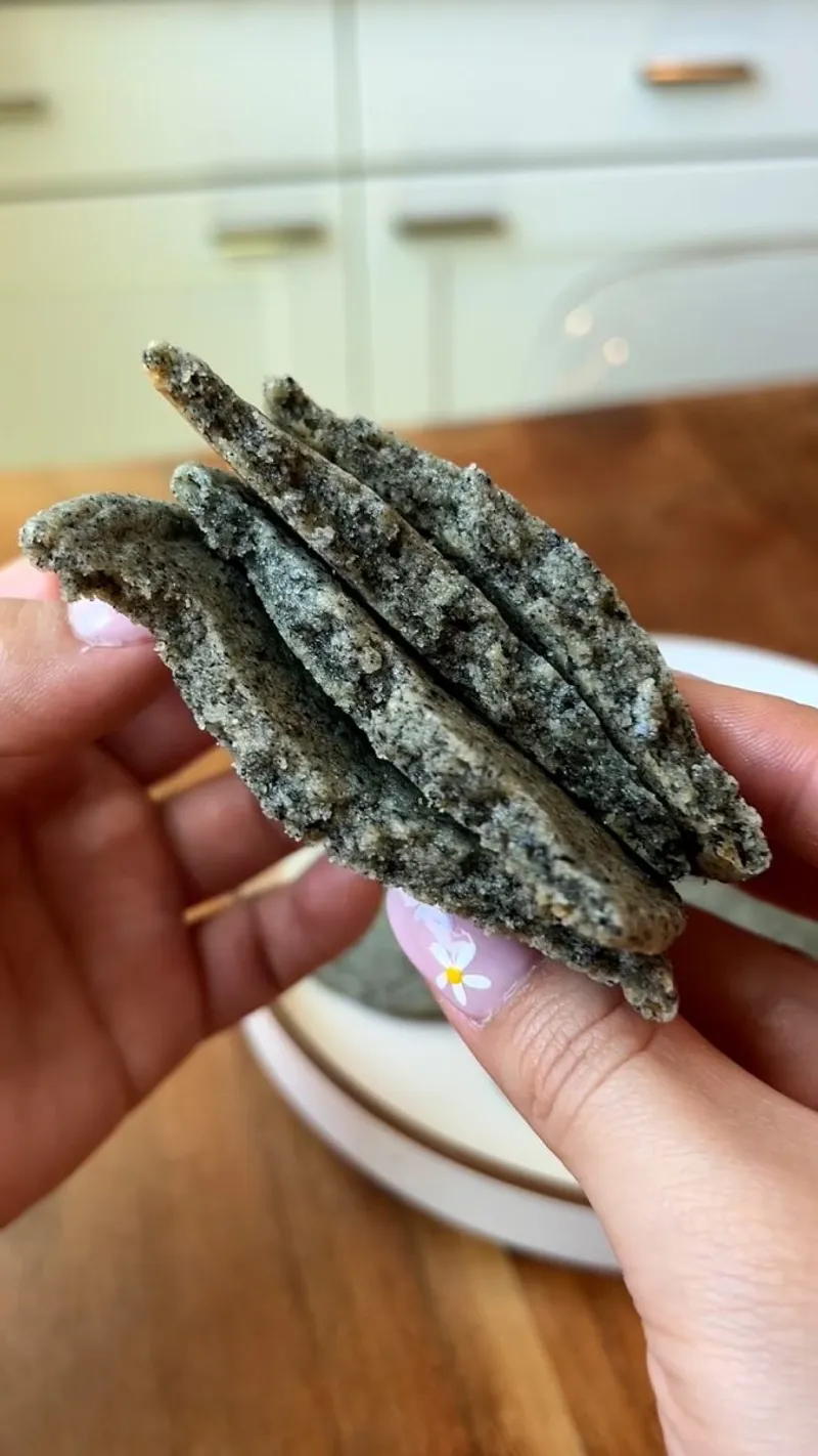 Cross-section of a soft and chewy black sesame cookie showing the dense, fudgy interior texture