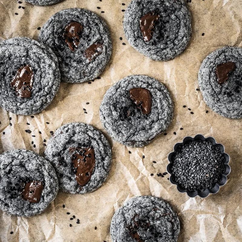 Overhead shot of soft and chewy black sesame cookies with chocolate centers on parchment paper