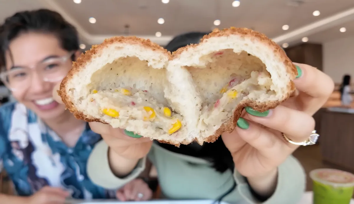 Close-up of the potato croquette bun cross-section showing corn, herb filling, and bread interior