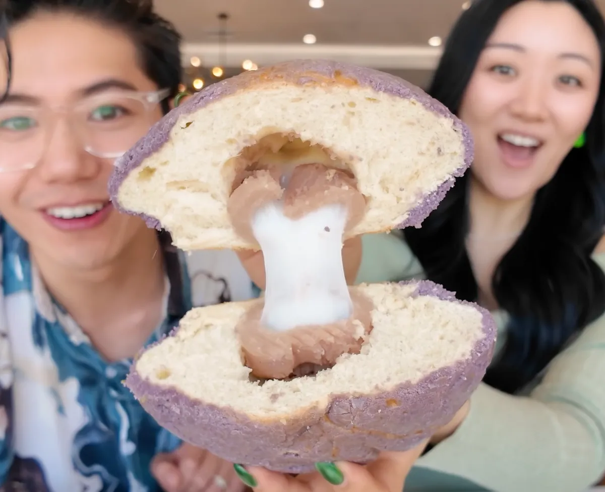 Jasmine and George holding the taro mochi ball broken open revealing taro paste and mochi filling inside