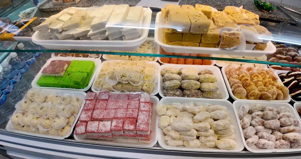 Bengali sweets display case with burfi, laddu, and assorted mithai at a Brick Lane pastry shop